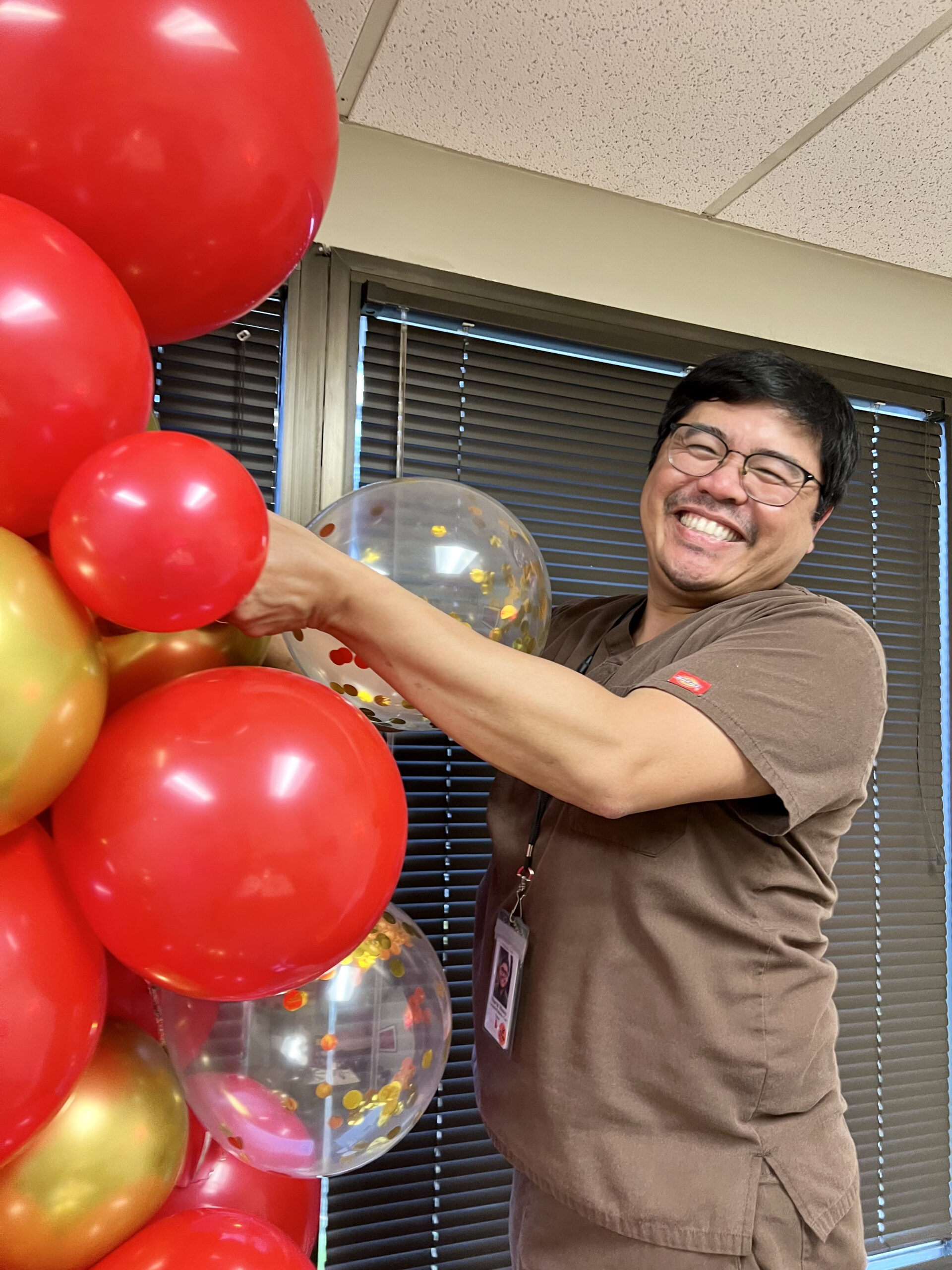 Marvic creating a balloon arch for a Mission Hospice event